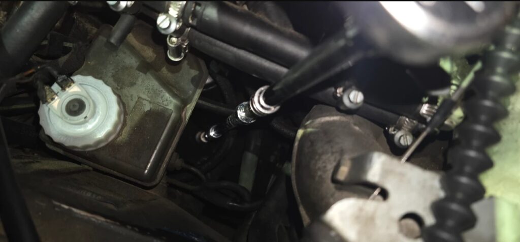 Swivel socket on an extension reaching the E30 control arm center ball joint nut from the top